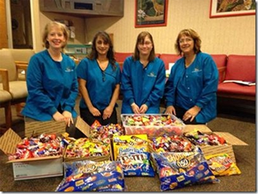 Staff posing with candy during Candy Buy Back Program